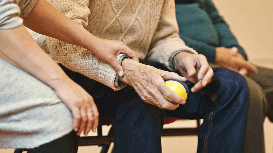 young person holding the arms of an elderly