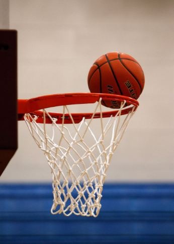 A basketball dropping into a basketball net