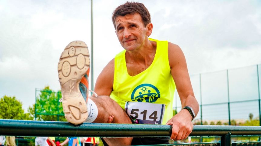 An older man stretching on a bar
