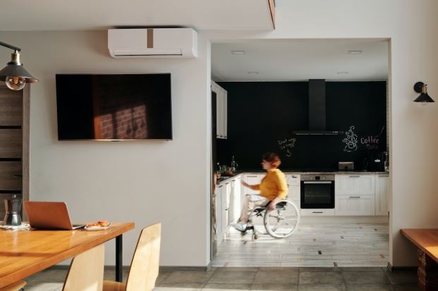 A woman in a wheelchair doing something in the kitchen