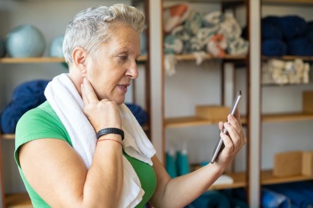 An elderly woman measuring her pulse after a workout