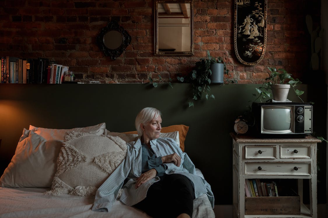 an elderly woman sitting on a bed
