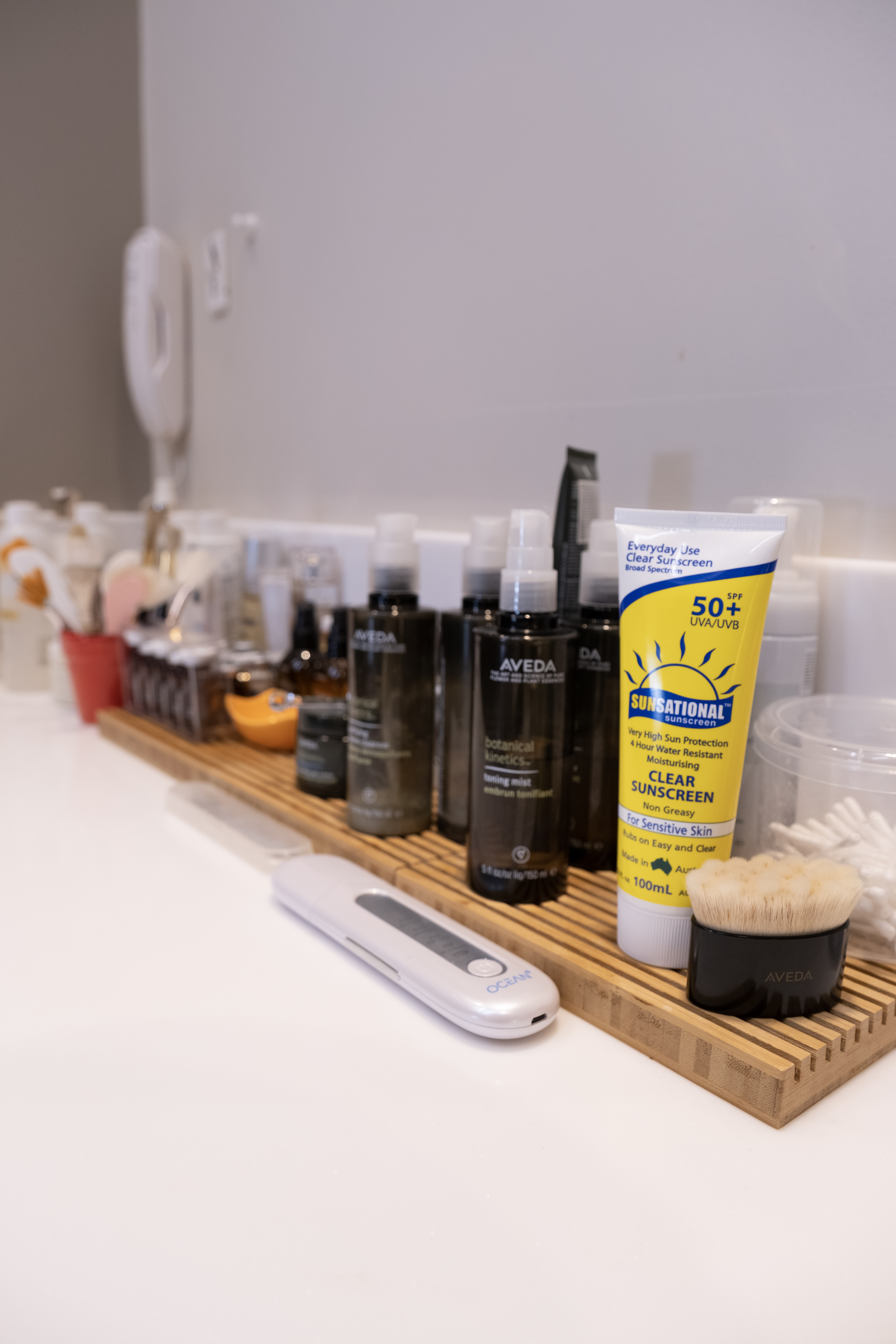 an organized beauty products bottles on shelf in bathroom