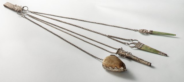 chatelaine of tuigje, in the olden days, women used to wear it to have their sewing kit ready to hand. This silver chatelaine is partly covered with stingray leather